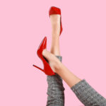 kobiece nogi w czerwonych szpilkach i kraciastych cygaretkach