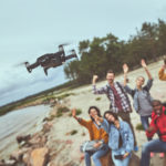 dron filmujący ludzi na imprezie na plaży
