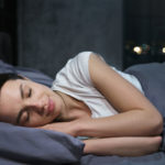 kobieta śpiąca w szarej pościeli