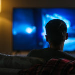 mężczyzna oglądający telewizję nocą